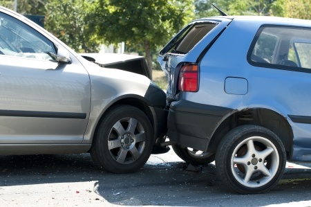 A silver car collided with the rear bumper of a blue car.